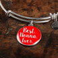 Silver bangle with a red charm that says 'Best Nonna Ever' on a wooden surface