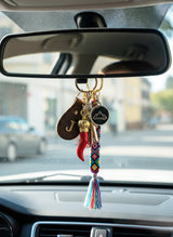 Car dashboard with a colorful keychain hanging from the rearview mirror.