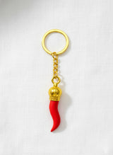 Red keychain with gold accents on a white background