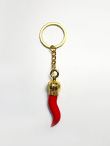 Red horn-shaped keychain with gold accents on a white background