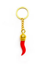 Red horn keychain with gold top on a white background