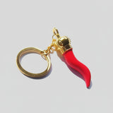 Keychain with red horn-like charm and gold accents on a white background