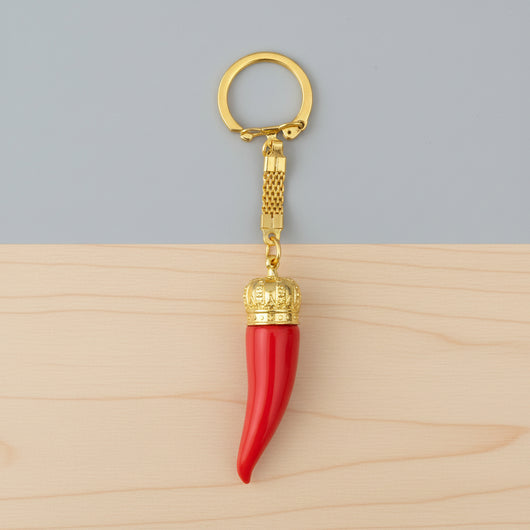 Red keychain with gold crown and gold ring on a white background