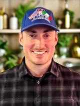 Man wearing a blue cap with 'U.S. Italian' text and smiling on a white background