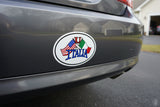 Car bumper with a sticker featuring the flags of the United States, Italy, and France.
